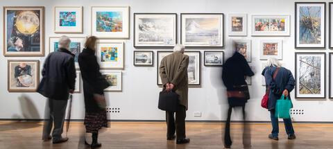 People looking at paintings in the gallery 