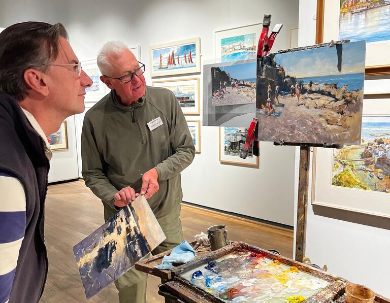 Two males looking at a painting