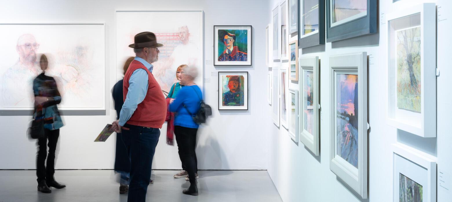 PS 2024 Installation Photo of visitors looking at artworks on the wall