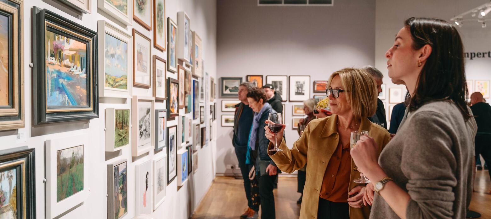 2 women looking at art on the walls