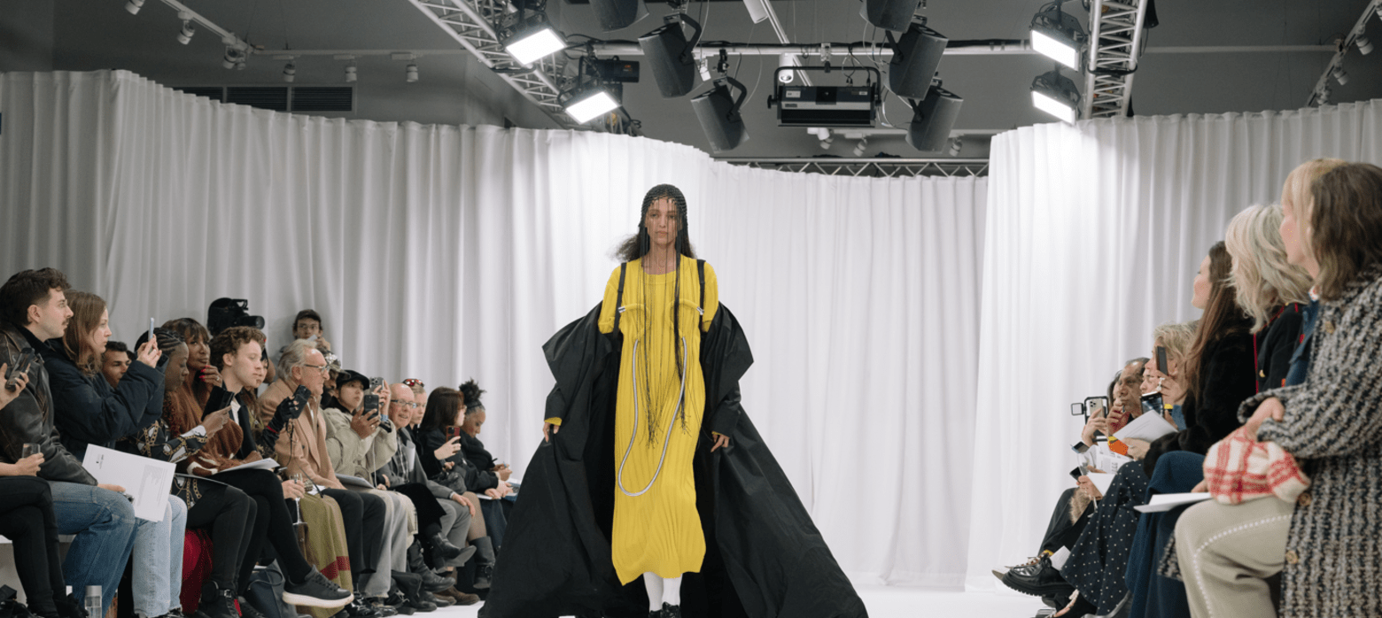 woman in a yellow dress walking down a runway