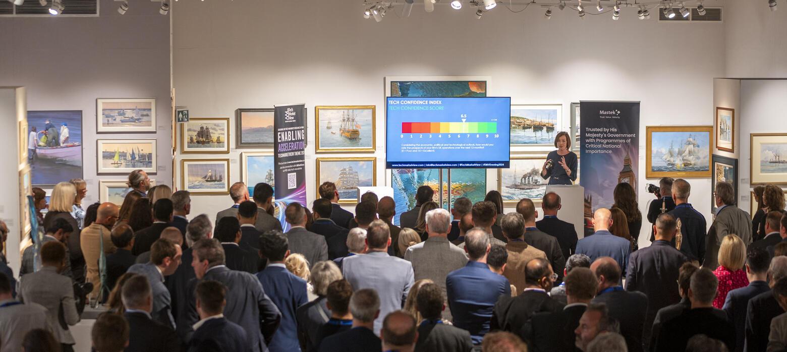 a crowd of people looking at a presentation taking place on stage