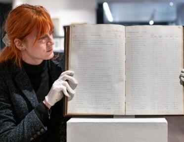 photograph of woman holding ROI records book