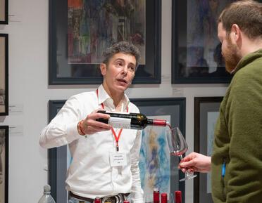 man pouring wine into a glass held by another man